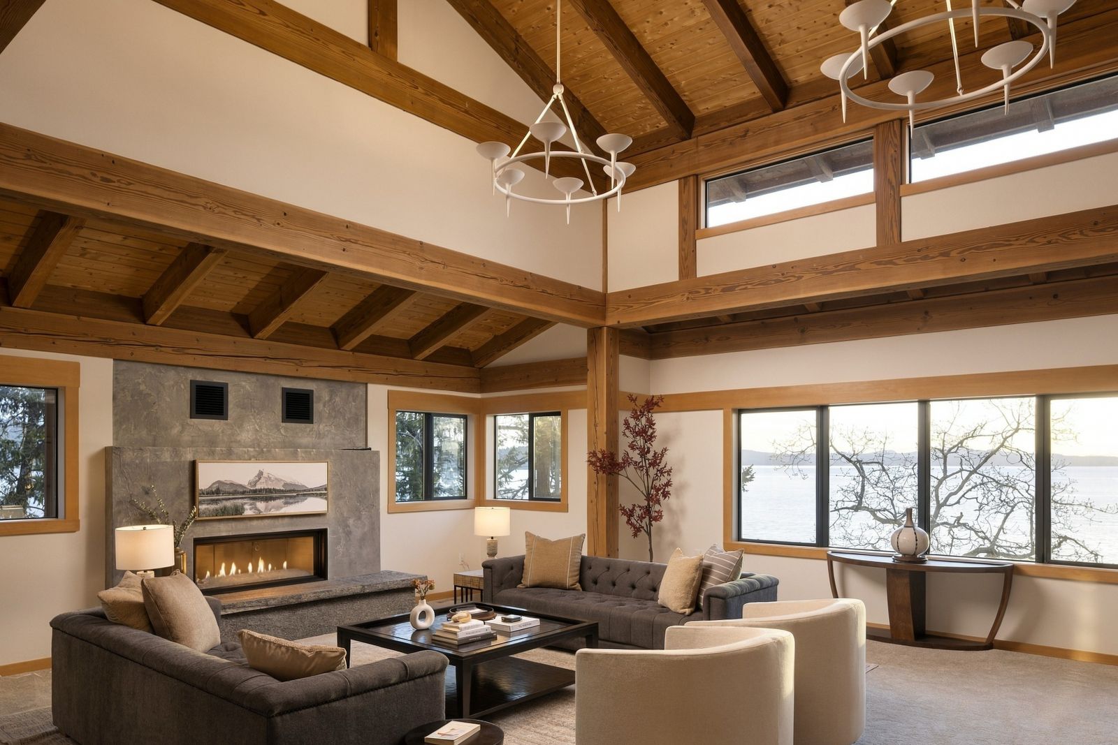 Living room at BrightWoods with beam vaulted ceiling, fireplace and windows toward the water